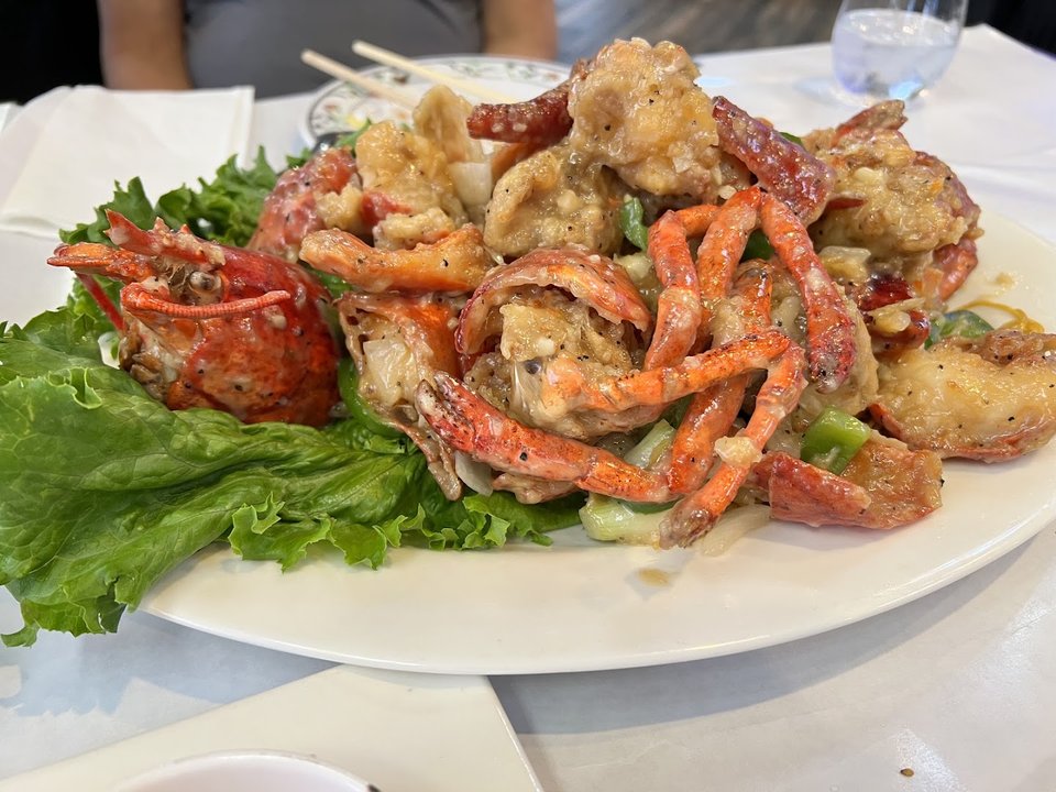 Outdoor seating beside a busy seafood restaurant.